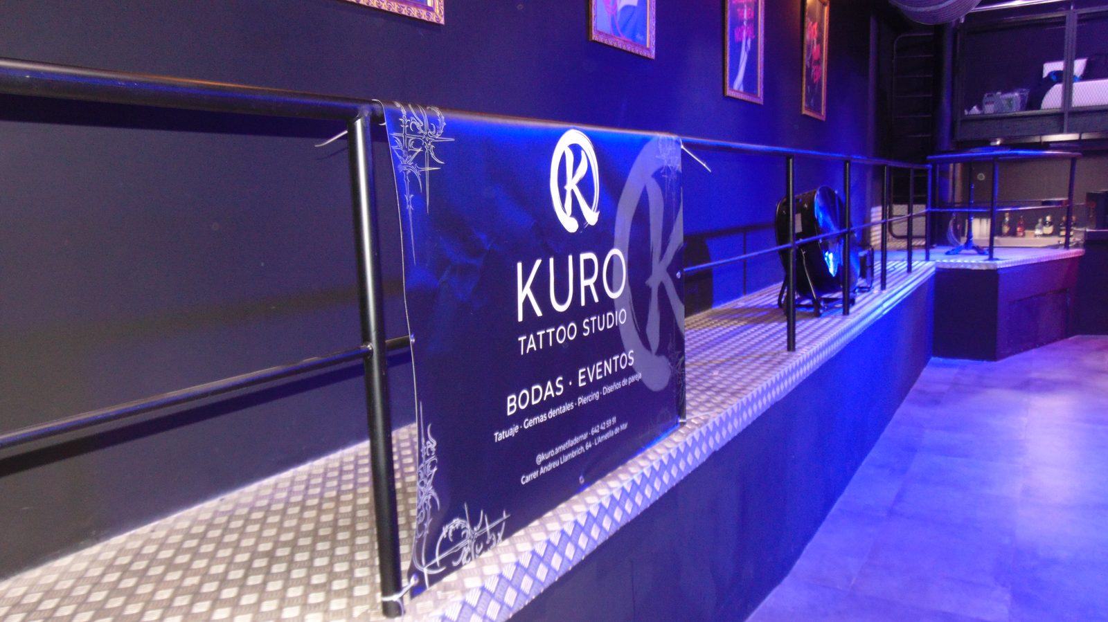 El stand de KURO con su lona, en un evento con luz azul